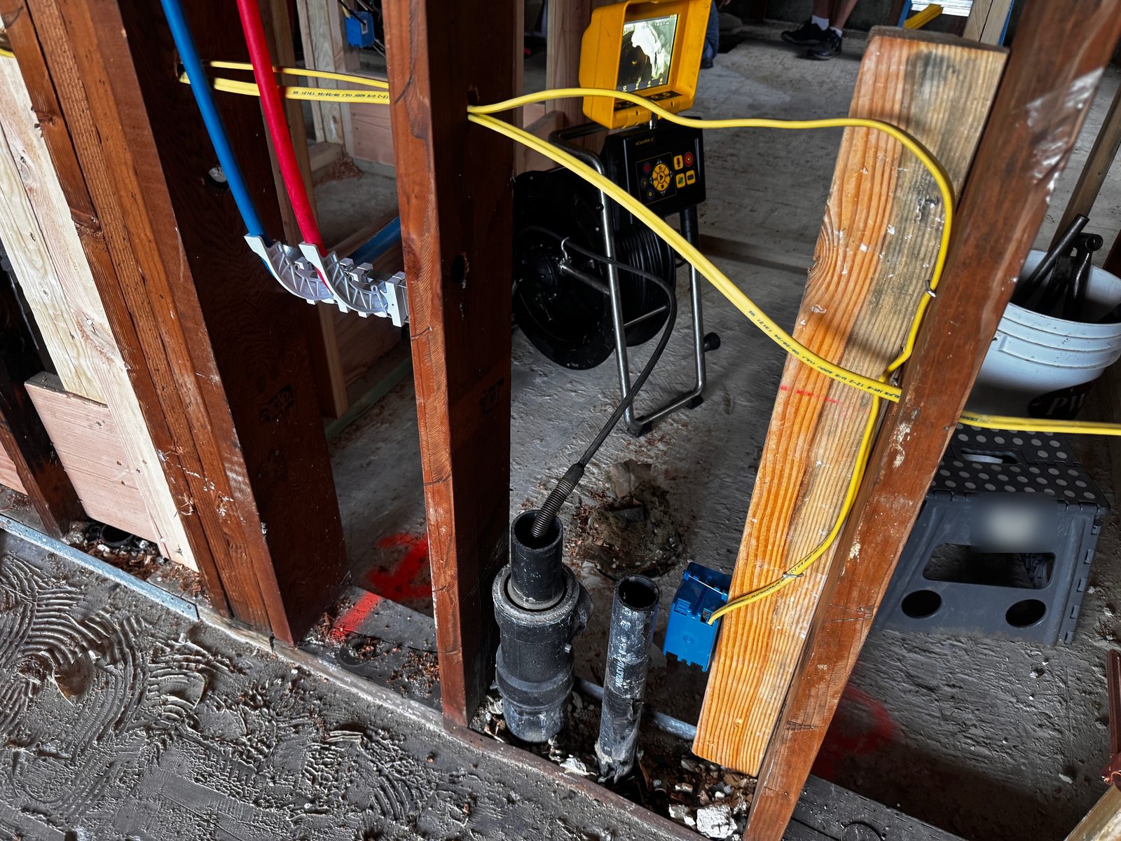Sewer camera cable entering the drain line at a downstairs bathroom during a remodel