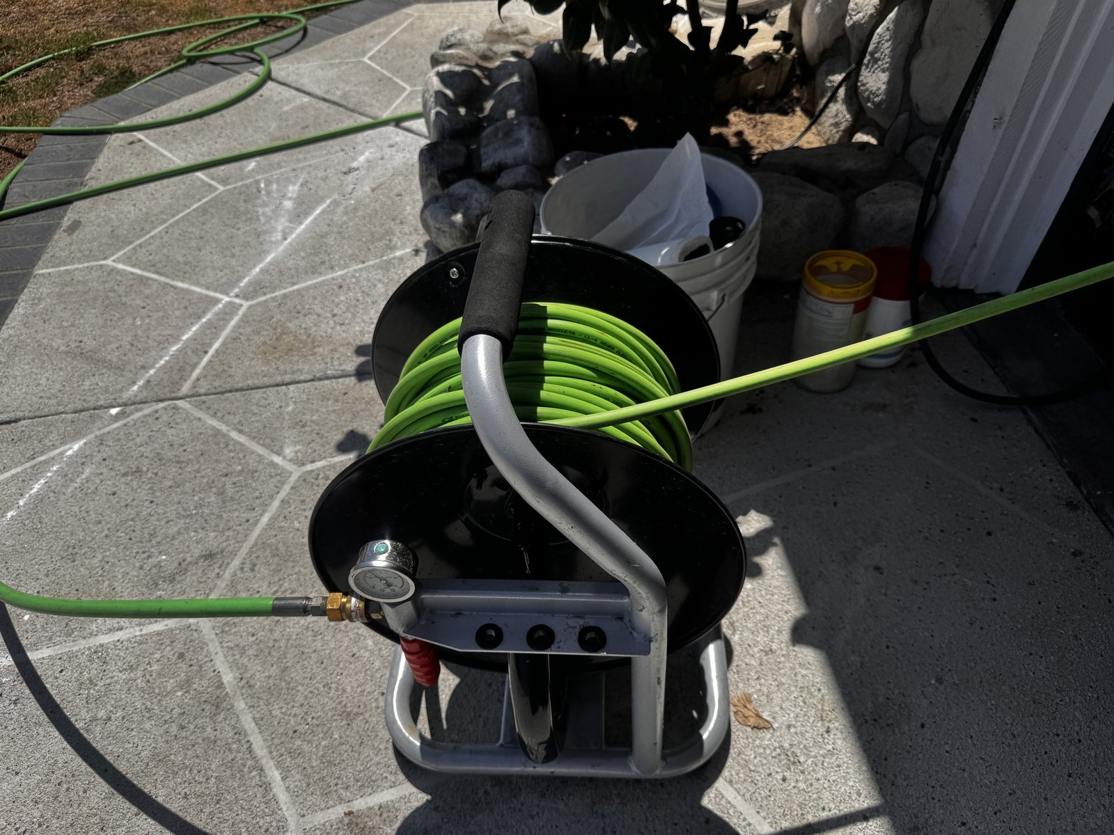 Hydro jetting hose reel set up on a residential property with the jetter line paid out toward the sewer cleanout