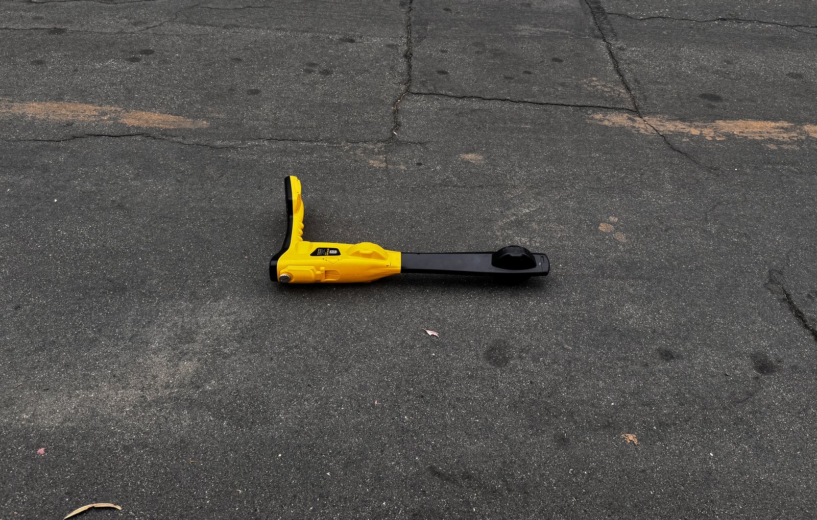 Sewer line locator wand resting on street pavement while tracing a main line route