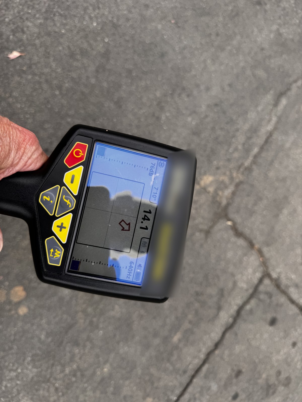 Handheld sewer line locator receiver displaying signal strength and a depth reading during a main line locate