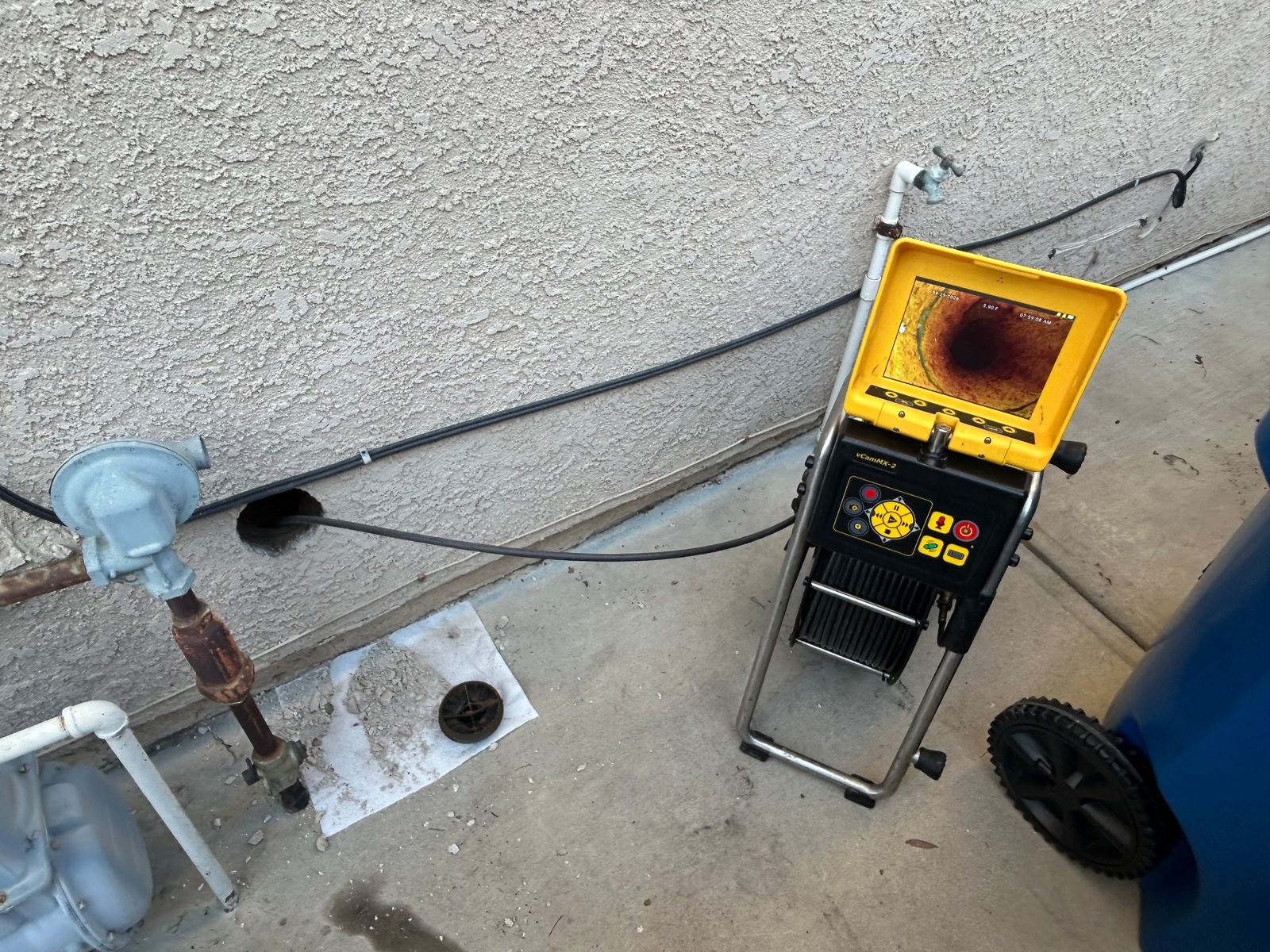 Sewer inspection camera running into a cleanout opened through stucco