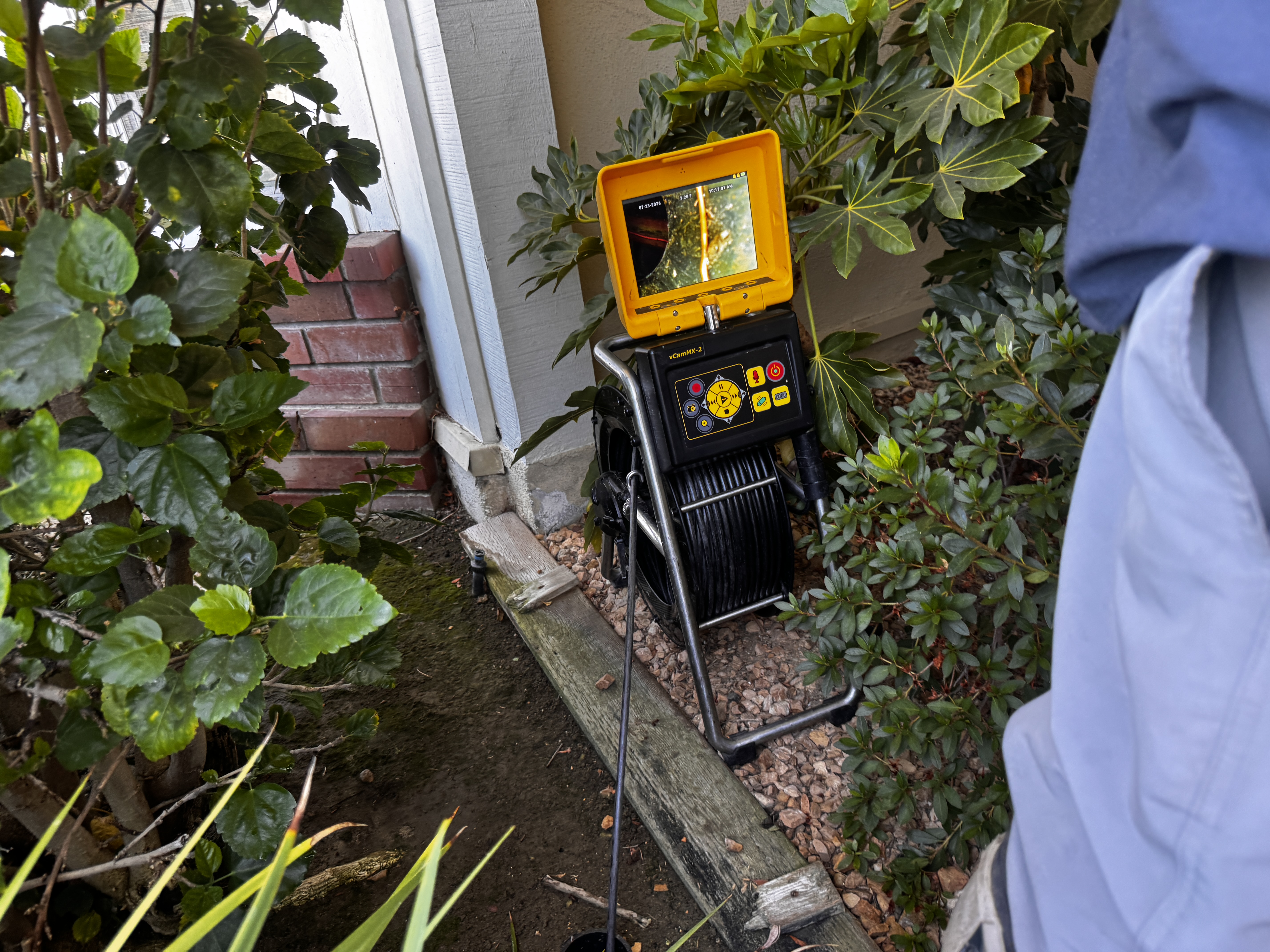 FlowPro camera reel and monitor staged at a residential sewer access point